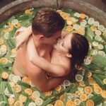 Intimate couple in a citrus bath, embracing passionately. Perfect for romantic and lifestyle themes.